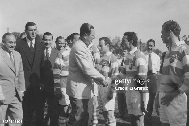 President of Argentina Juan Domingo Peron shakes hands with Osvaldo Bernacchi of Argentina National Rugby Team after being presented by the captain...