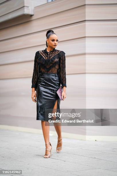 Miss France 2017 Alicia Aylies wears earrings, a see-through black lace frilly blouse, a black bag, a black crocodile pattern side-slit skirt,...