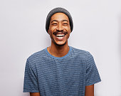Laughing young man standing against a gray background