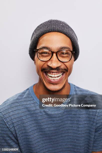 laughing young man wearing glasses standing against a gray background - man expressive background glasses stock pictures, royalty-free photos & images