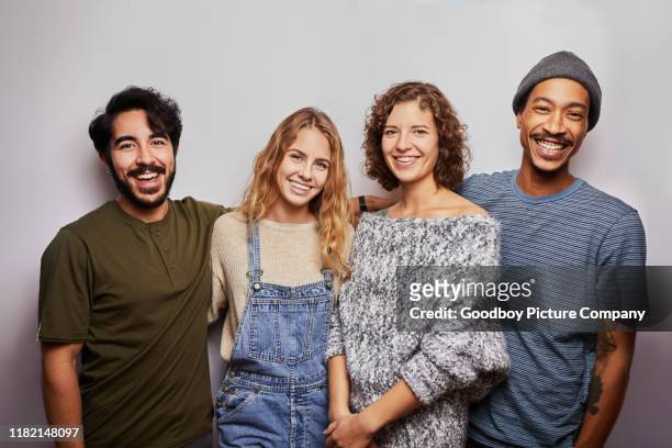 smiling group of diverse young friends against a gray background - young men group stock pictures, royalty-free photos & images