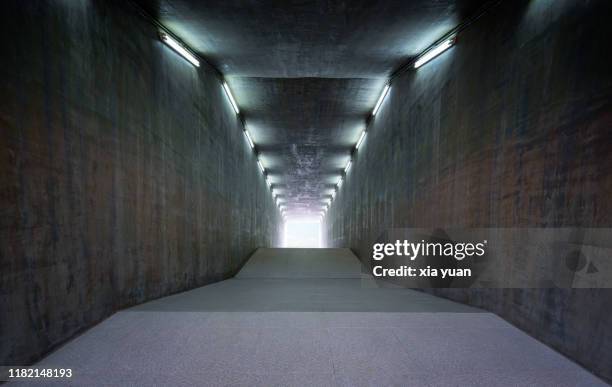 illuminated empty concrete tunnel - narrow stockfoto's en -beelden