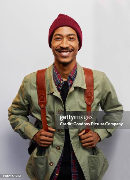 smiling young man wearing hiking gear on a gray background - hiking backpack stock pictures, royalty-free photos & images