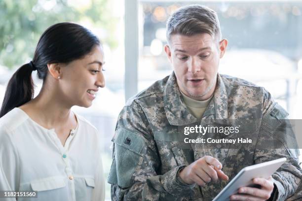 militare in possesso di tablet digitale in ufficio assunzioni - recruiter foto e immagini stock