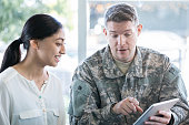 Military man holding digital tablet in recruitment office