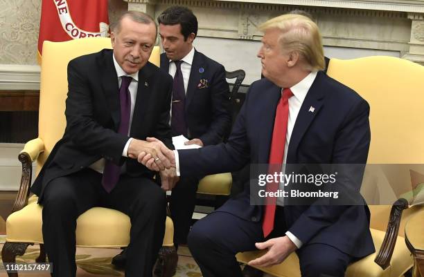 President Donald Trump, shakes hands with Recep Tayyip Erdogan, Turkey's president, left, during a meeting at the Oval Office of the White House in...