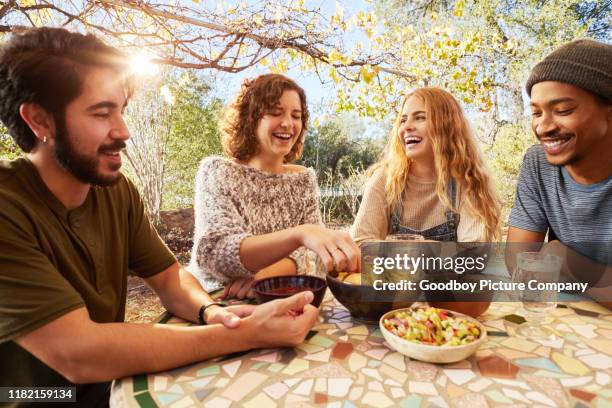 laughing friends eating nachos togegher on an outdoor patio - dip stock pictures, royalty-free photos & images