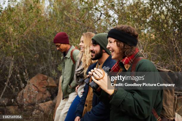 smiling young friends using binoculars during a nature hike - bird watching stock pictures, royalty-free photos & images