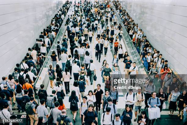 crowd of busy commuters walking through platforms at subway station during office peak hours in the city - hauptverkehrszeit stock-fotos und bilder