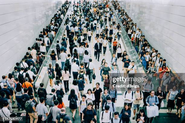 crowd of busy commuters walking through platforms at subway station during office peak hours in the city - hora punta temas fotografías e imágenes de stock