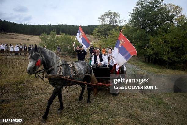 Chinese tourists wear traditional dresses as they take a part in a Serbian wedding show for tourists in an ethno village Gostoljublje, near central...