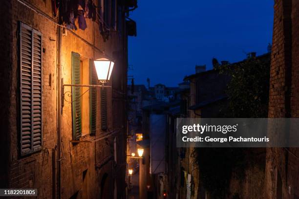 street lamp in the old town of siena, italy at night - dark sienna stock pictures, royalty-free photos & images