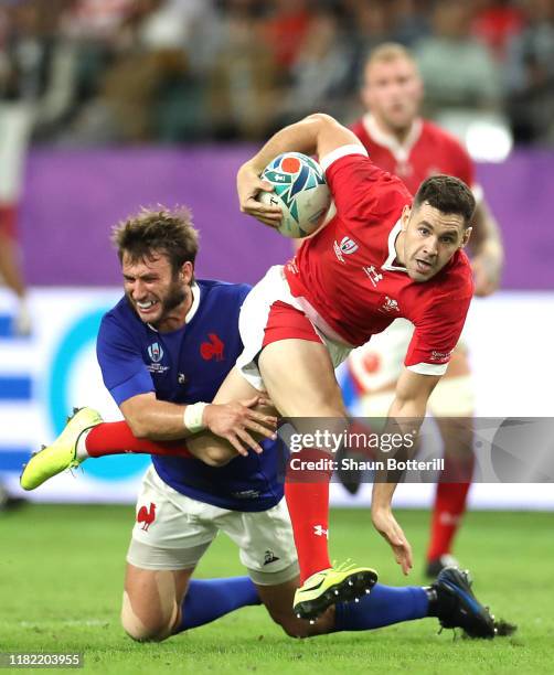 Tomos Williams of Wales is tackled by Maxime Medard of France during the Rugby World Cup 2019 Quarter Final match between Wales and France at Oita...