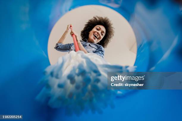 a continuación, la vista de la mujer negra feliz sumergiendo la fregona en el cubo. - daily bucket fotografías e imágenes de stock