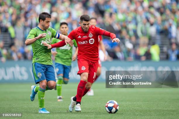 Toronto FC midfielder Alejandro Pozuelo tries to separate from Seattle Sounders forward Nicolas Lodeiro during the second half of the Major League...
