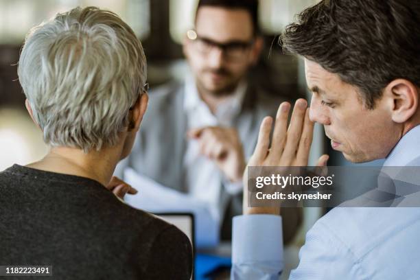 business colleagues whispering on a meeting in the office. - mexerico imagens e fotografias de stock