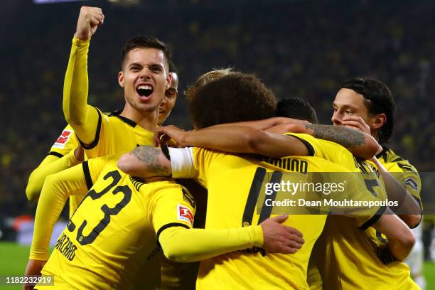 Marco Reus of Borussia Dortmund celebrates scoring his teams first goal of the game with team mates during the Bundesliga match between Borussia...