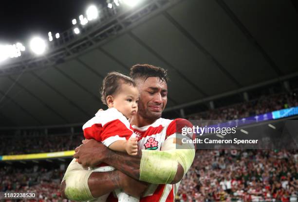 Amanaki Mafi of Japan tears up as he holds his child following defeat in the Rugby World Cup 2019 Quarter Final match between Japan and South Africa...