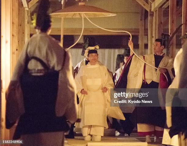 Japanese Emperor Naruhito clad in white traditional attire heads to the Yuki Hall, part of the gigantic Daijokyu Halls, to perform the "Daijokyu no...