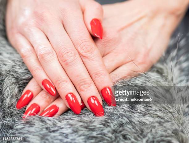 close-up of woman fingers with nail art manicure with bright red color - レッドマニキュア ストックフォトと画像