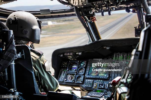 pilota di elicotteri dell'esercito in sella a un elicottero militare - military helicopter foto e immagini stock