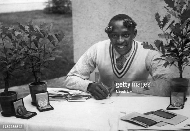 Champion "Jesse" Owens signs autographs in August 1936 during the Olympic Games in Berlin where he captured 4 gold medals, 100m, 200m, 4x100m and...