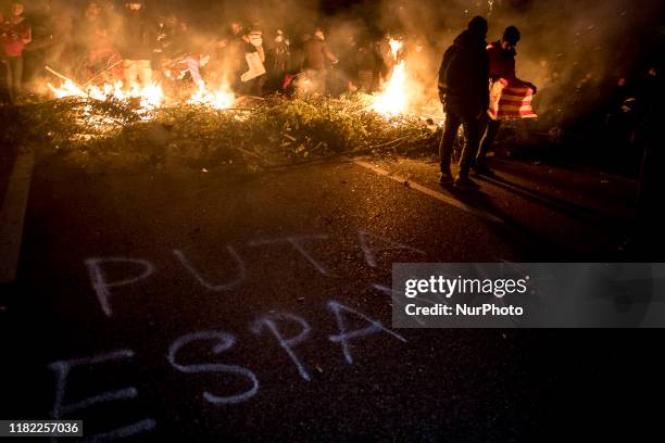 Graffity whith the text &quot;Puta Espanya&quot; . Catalan independent activists summoned by TsunamiD block with cars and barricades, the AP7...