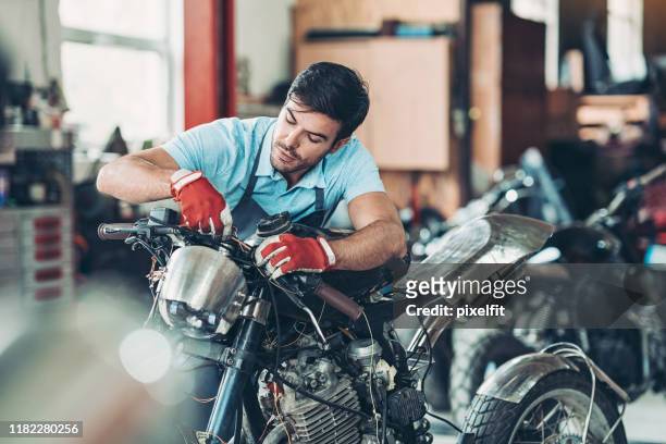 jonge man werkt in auto repair shop - bike mechanic stockfoto's en -beelden