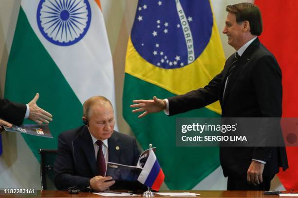 Brazil's President Jair Bolsonaro and Russian President Vladimir Putin attend to a meeting with members of the Business Council and management of the...