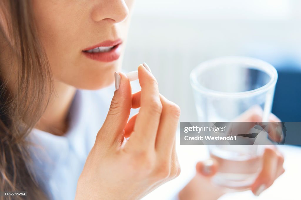 Close up of woman taking pill