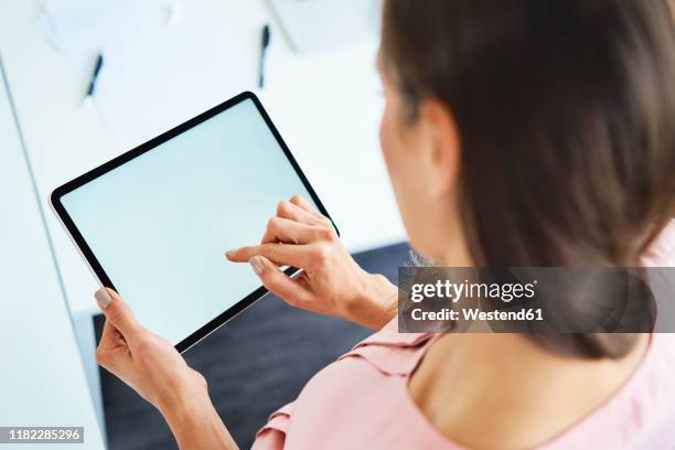 overhead view of woman using tablet in office - raised finger stock-fotos und bilder