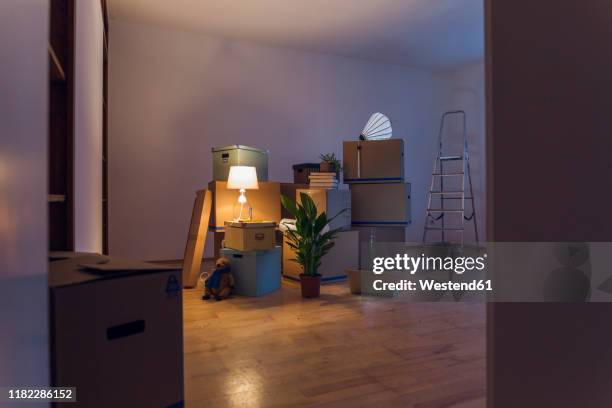 cardboard boxes in an empty room in a new home - light box stock-fotos und bilder