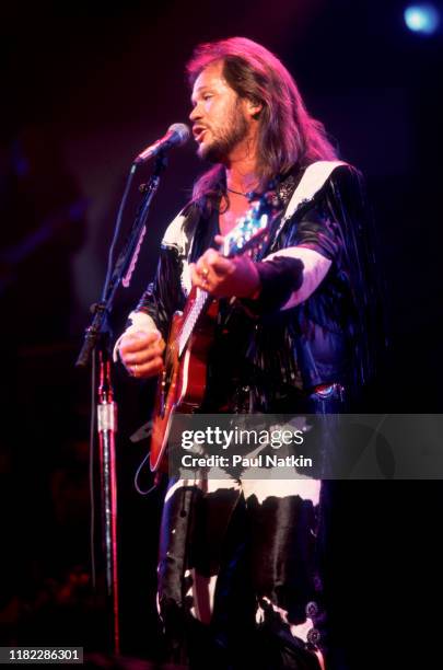 American Country musician Travis Tritt plays guitar as he performs onstage at the Star Plaza Theater, Merrillville, Indiana, August 15, 1995.