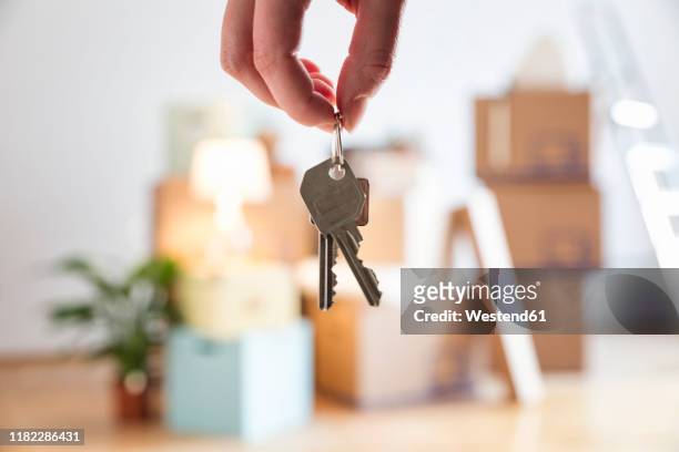 close-up of woman holding house key in new home - selling foto e immagini stock