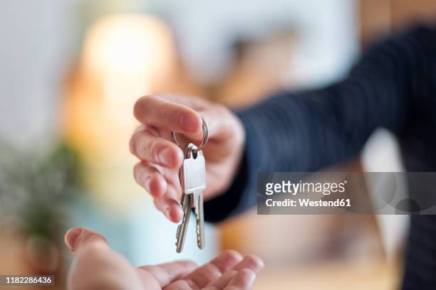 close-up of hand over of house key in new home - house keys - fotografias e filmes do acervo
