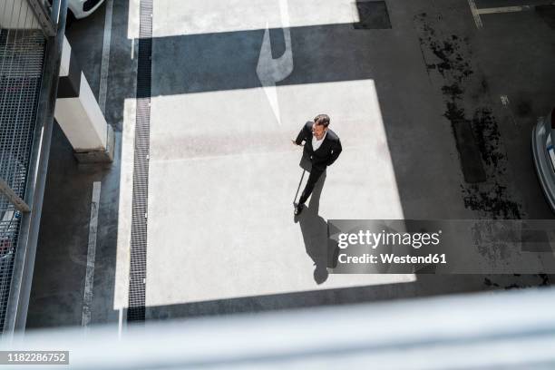 top view of businessman with baggage on the go - aerial walking stock-fotos und bilder