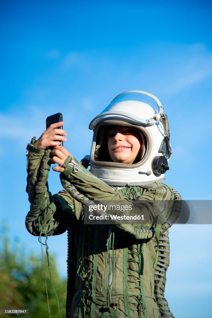 Boy wearing a space suit and taking a selfie