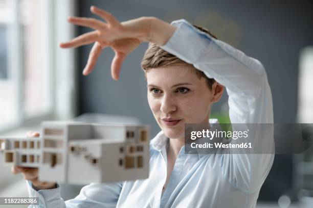 confident businesswoman holding architectural model in office - shirt mockup stock pictures, royalty-free photos & images