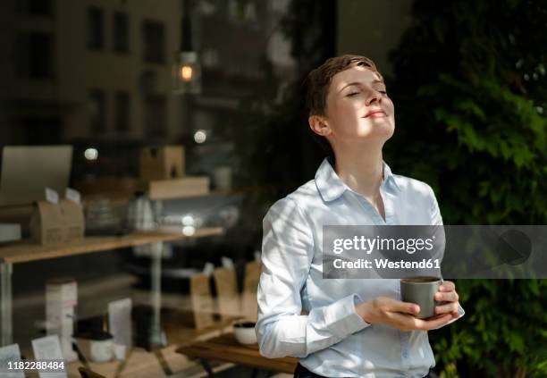 relaxed businesswoman having a coffee at a cafe - einfaches leben stock-fotos und bilder