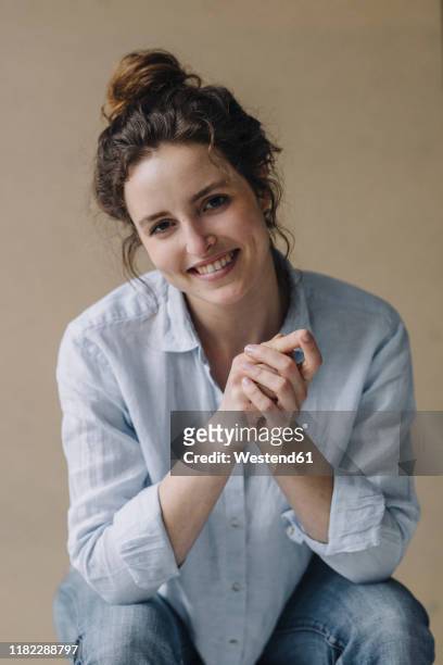 portrait of smiling young woman with bun - blouse stock pictures, royalty-free photos & images
