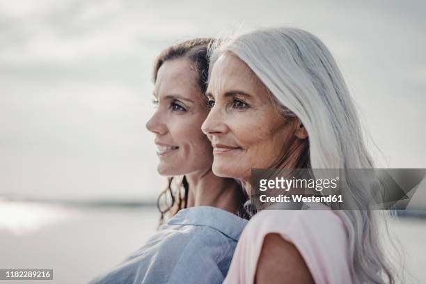 mother and daughter spending a day at the sea, portrait - madre e hija belleza fotografías e imágenes de stock