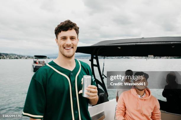 happy friends having a drink on a boat trip on a lake - holding beer stock pictures, royalty-free photos & images