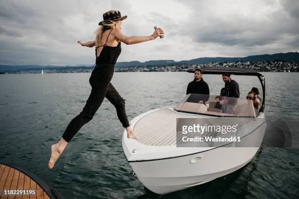 young woman jumping on a boat on a lake - lake zurich stock pictures, royalty-free photos & images