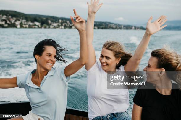 happy female friends having fun on a boat trip on a lake - lake zurich switzerland stock pictures, royalty-free photos & images
