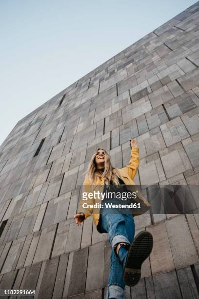 laughing young woman balancing on one leg, vienna, austria - low angle view stock pictures, royalty-free photos & images