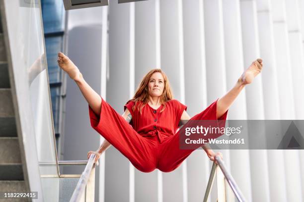 sporty young woman doing acrobatics on a railing - jumpsuit stock pictures, royalty-free photos & images