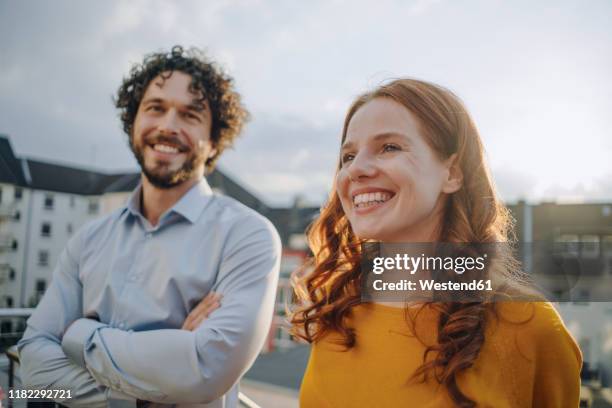 two happy colleagues on roof terrace - rote haare stock-fotos und bilder