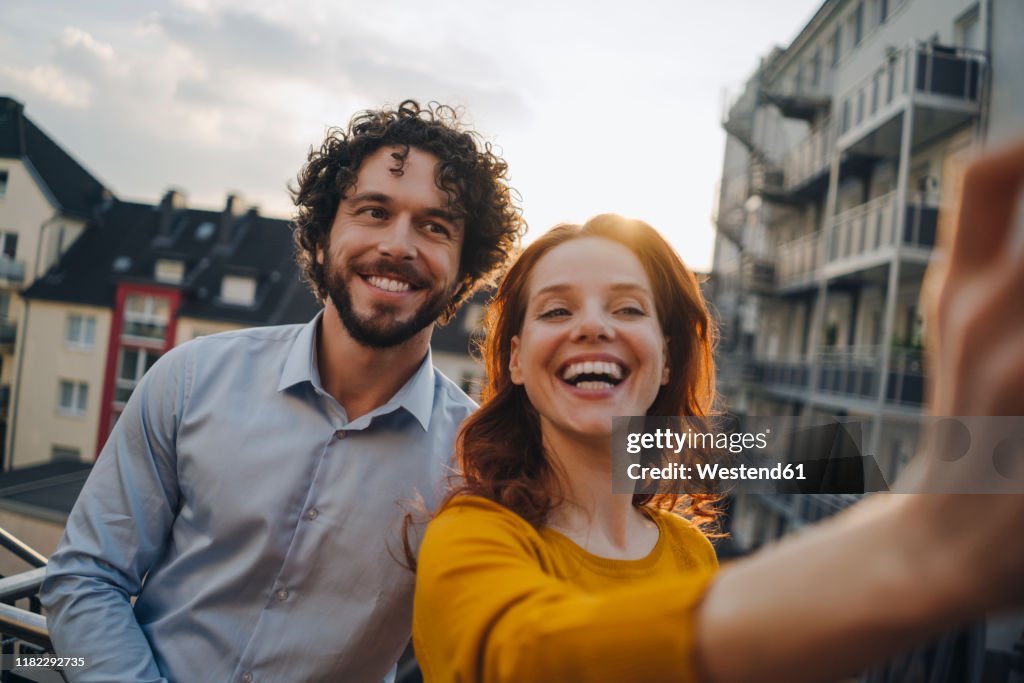 Two happy colleagues on roof terrace taking a selfie