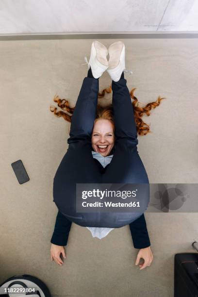 businesswoman lying on the floor in office exercising - long legs women stock-fotos und bilder