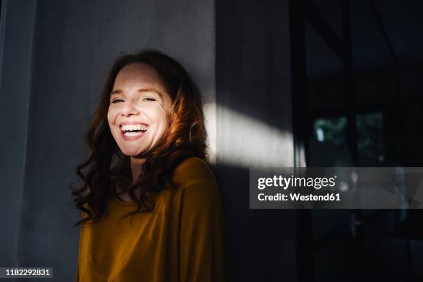 portrait of laughing redheaded woman with light and shadow - casual headshot stock pictures, royalty-free photos & images